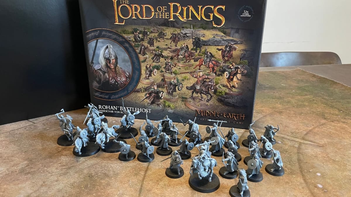 The forces of the Middle-earth Strategy Battle Game Rohan Battlehost assembled unpainted in front of their box. A mix of cavalry and on-foot soldiers.