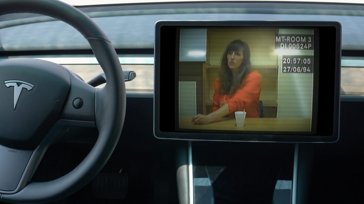 The main character of Sam Barlow's game Her Story superimposed onto a Tesla dashboard