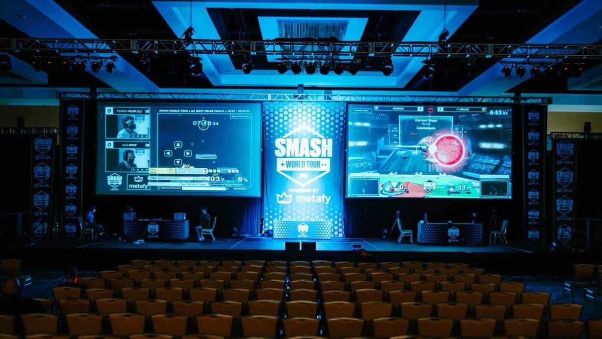A mostly empty theater for the Smash World Tour event, with matches being shown on both screens