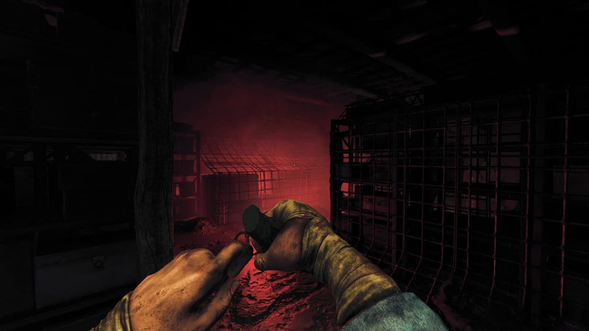 Amnesia The Bunker header of the player pulling the pin on a grenade in a red lit room with a metal cage