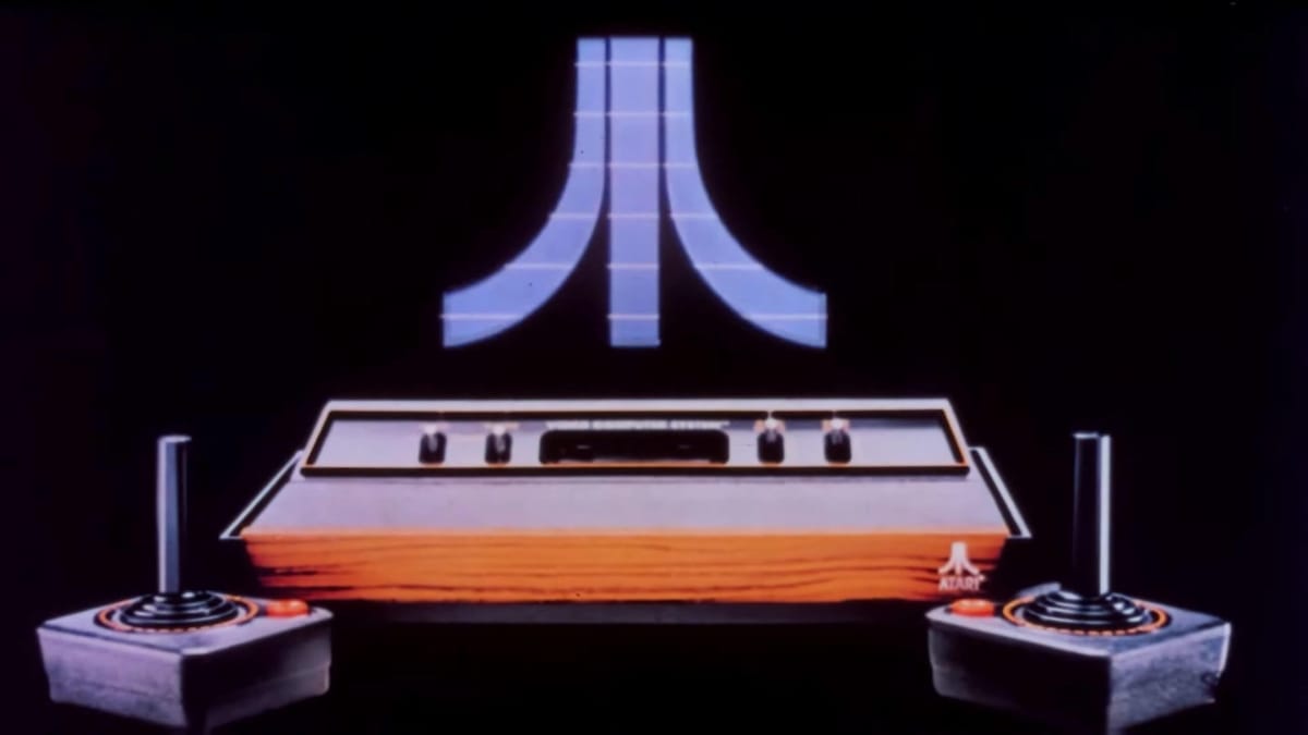 An Atari console flanked by two joysticks and the Atari logo
