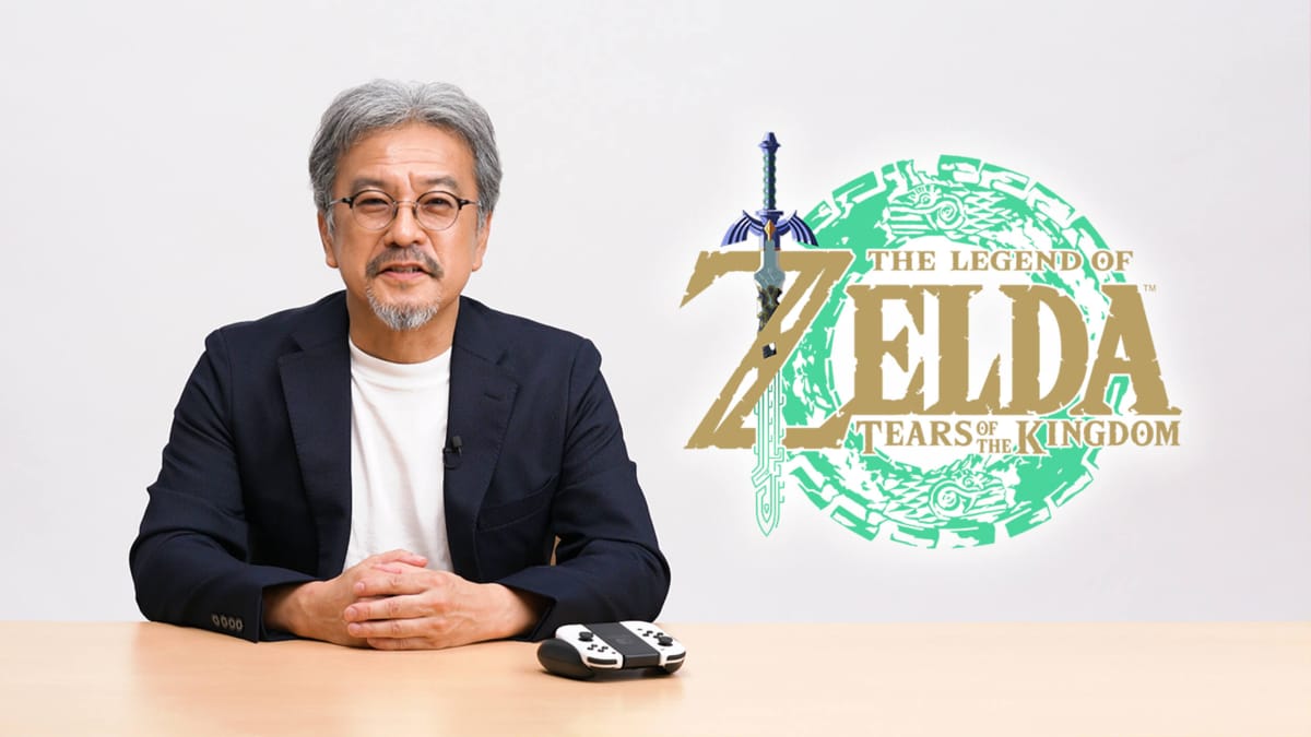 Eiji Aonuma sitting next to a logo for The Legend of Zelda: Tears of the Kingdom