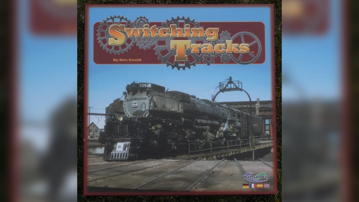 Switching Tracks Game Cover depicting a turn-of-the-century steam engine in a rural desert-esque location, with a wooden sign towards the top that displays the game's name. 
