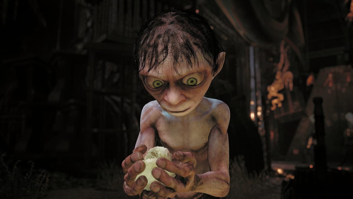 Gollum screenshot showing gollum looking curiously at a small bird he is holding in his hands. 