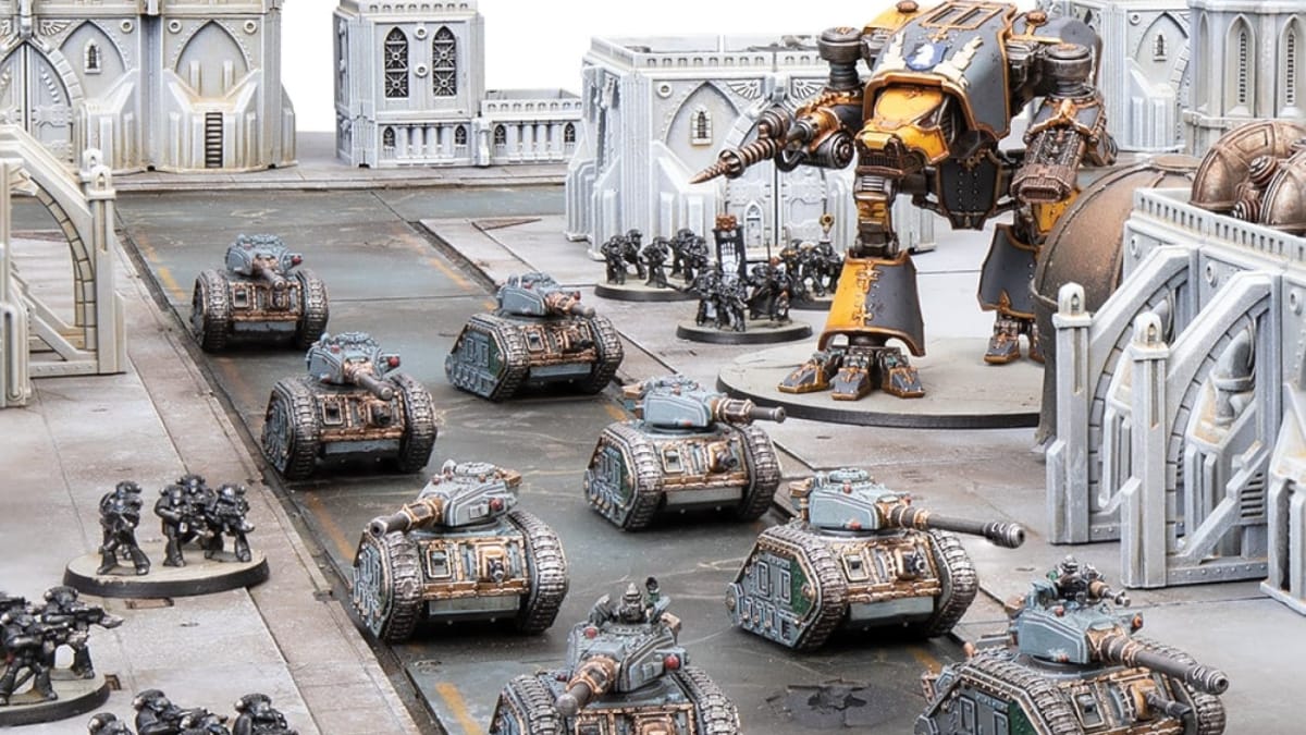 A war table featuring white gothic buildings, a giant mech in the background, groups of tanks patrolling down a road, and several units accompanying them.