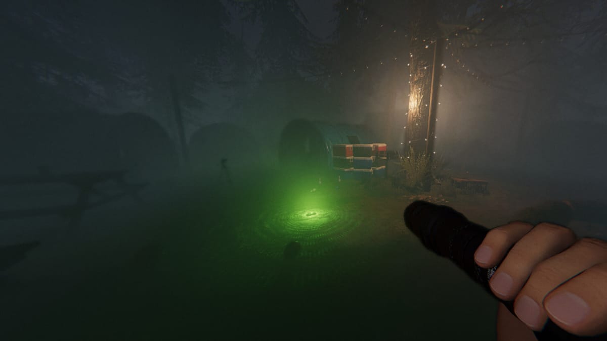 The player holding a torch and investigating an illuminated campsite in Phasmophobia