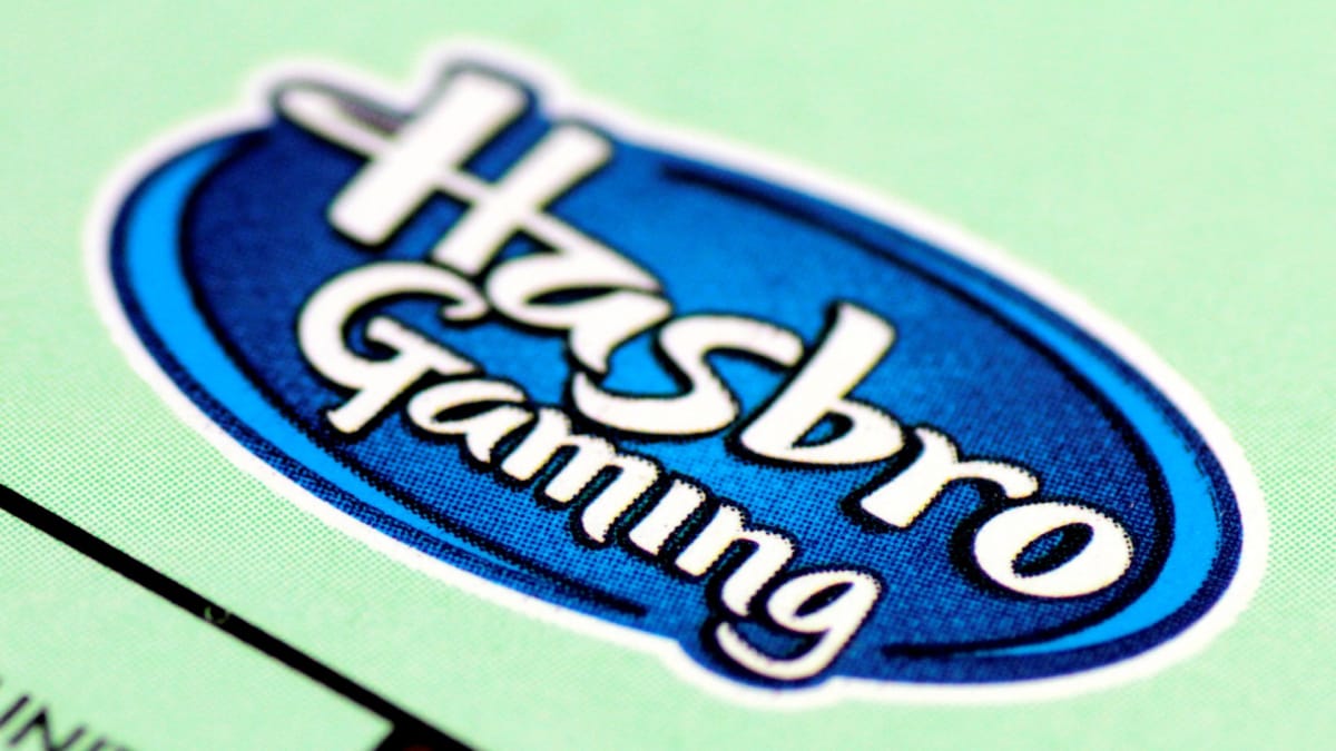 The logo for Hasbro Gaming printed on a green Monopoly board.