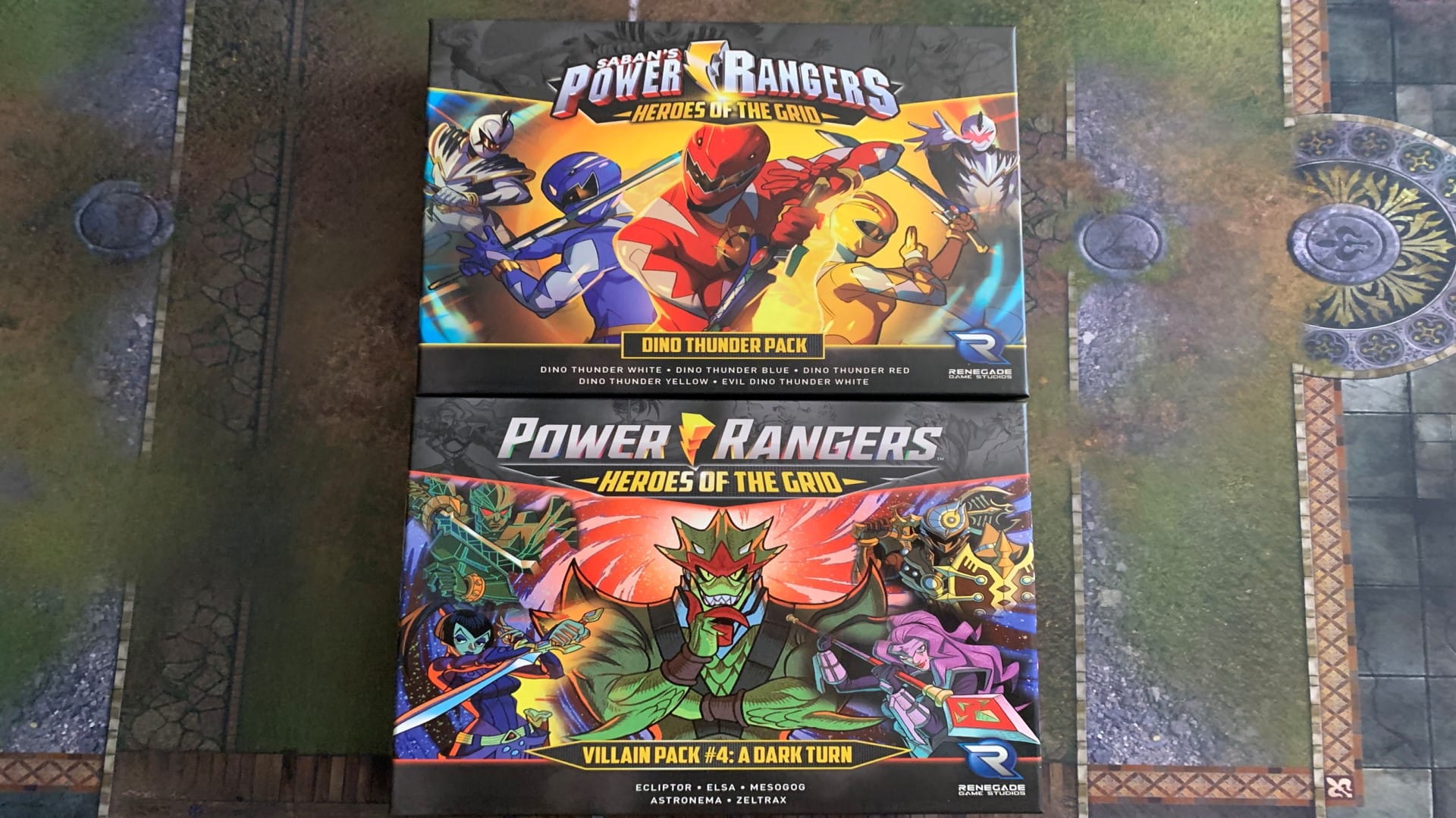 The boxes for the Power Rangers Dino Thunder Pack and Villain Pack 4 on a playmat