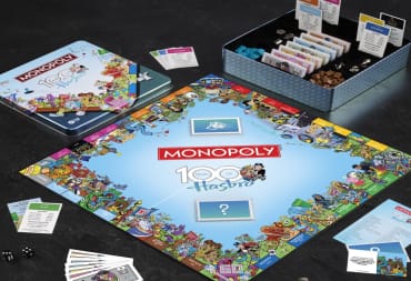 The board set up for Monopoly: Hasbro 100th Anniversary Edition showing cards, locations, and game pieces.