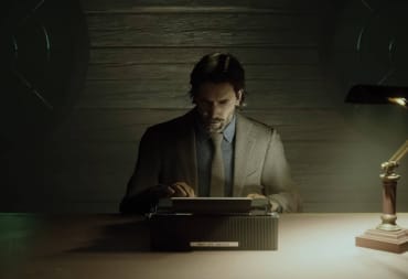 Alan Wake anxiously hammering away at a typewriter while sitting at a desk in Alan Wake 2