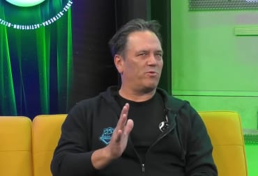 Phil Spencer in the middle of saying something while sitting on a sofa during an Xbox interview