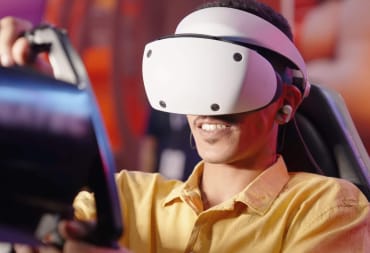 A person wearing a PlayStation VR2 headset and using a steering wheel peripheral