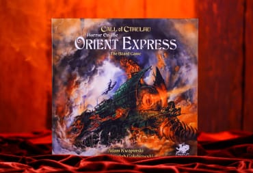 A promotional image of Horror On The Orient Express: The Board Game, showing the board game on a dark red velvet cover.